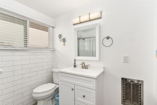 纽波特海滩West Newport Duplex on the Sand with Patio-Sleeps 12的白色的浴室设有卫生间和水槽。
