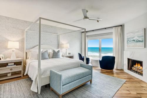 阿米莉亚岛Elegant Oceanfront Penthouse with Panoramic view, Omni Resort, Sea Dunes的一间卧室设有一张天蓬床和一个壁炉