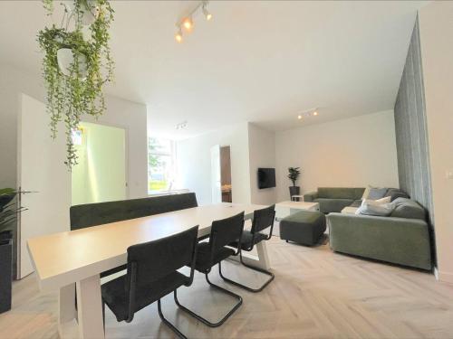 罗森达尔New Luxurious Apartment With 2 Bedrooms & Garden的客厅配有桌椅和沙发