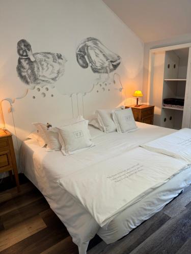 洛萨达Casa de Juste的卧室配有白色床和壁画