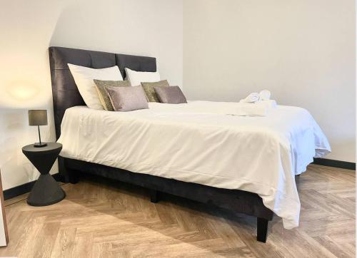 蒂尔堡Cozy Studio Unit With Kitchen & Bathroom的卧室配有一张带白色床单和枕头的大床。