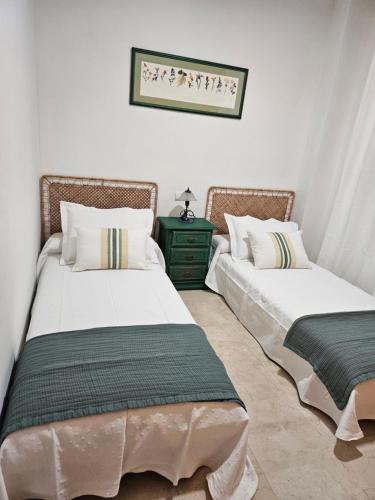 贝纳尔马德纳Arenal golf Sun & golf的两张睡床彼此相邻,位于一个房间里