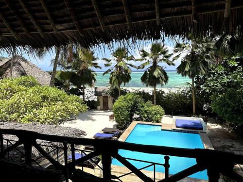 马特姆维Villa Maua Exclusive的享有带游泳池和大海的度假胜地的景致
