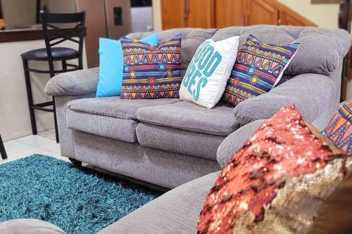 PiarcoTravelholics Getaways的客厅配有带色彩缤纷枕头的灰色沙发
