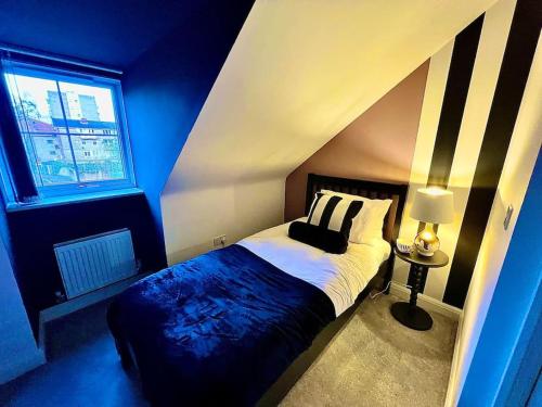 伯明翰Lotus Haus - Wyndale Living -W/off road Parking的蓝色的卧室,配有一张带黑白条纹墙的床
