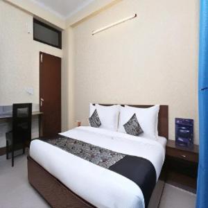 纳威孟买New Bramharaj By Glitz Hotels的酒店客房设有一张大床和一张书桌。