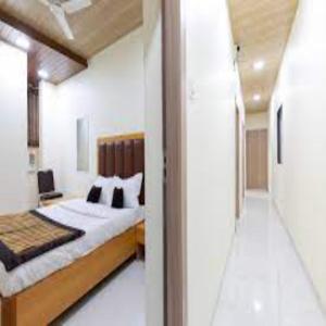 纳威孟买New Bramharaj By Glitz Hotels的一间卧室设有一张大床和一个走廊