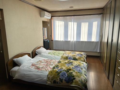 各务原市Shin-SHIN-Kakamigahara - Vacation STAY 16114的一间小卧室,配有两张带花卉图案的床铺