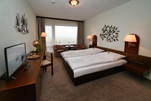 比苏姆Strandhotel Salty的一间卧室配有一张床、一张书桌和一台电视