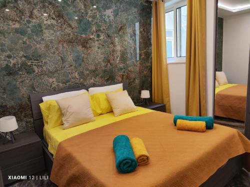 萨奈特Luxury Sanap Heights apartment with communal pool的一间卧室配有两张带黄色和蓝色枕头的床