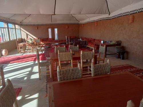 MhamidCouleur du désert的一间空餐厅,房间内设有桌椅