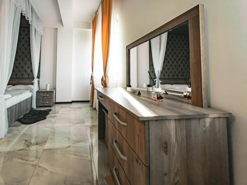 皮特什蒂Splendor Boutique Pitesti的浴室配有带大镜子的木制梳妆台