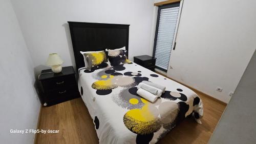 奥迪韦拉什Ap Central Chic的一间卧室配有一张带黑色和黄色棉被的床