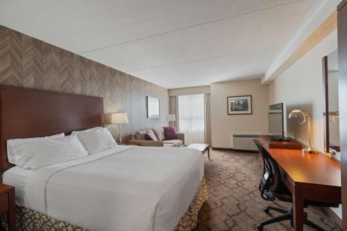 彼得伯勒奥托拿比贝斯特韦斯特酒店的酒店客房设有一张大床和一张书桌。