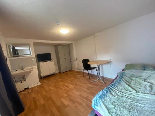 BrombachtalEinfache Schlafmöglichkeit mit Gemeinschaftsküche und Bad的一间卧室配有一张床、一个水槽和一张桌子