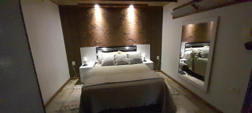 拉帕洛马Angeles的一间卧室配有一张大床和镜子