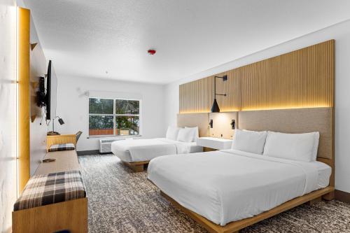 麦考尔The Evergreen Hotel的一间酒店客房,设有两张床和电视