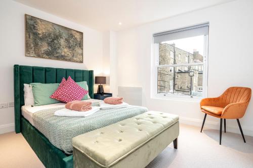 伦敦Belgravia Residence的一间卧室配有一张绿色的床、椅子和窗户