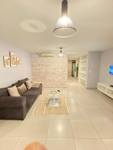 温特和克Windhoek Oliver perfect stays的带沙发和砖墙的客厅