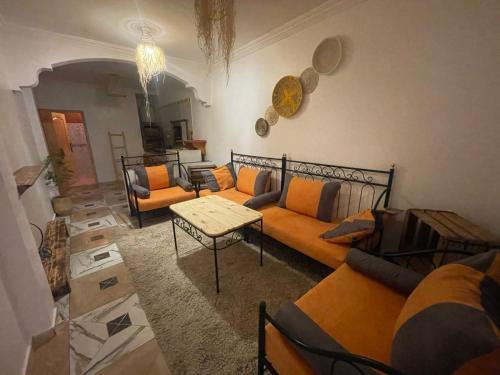 阿加迪尔Heaven Surf Camp的客厅配有橙色沙发和桌子