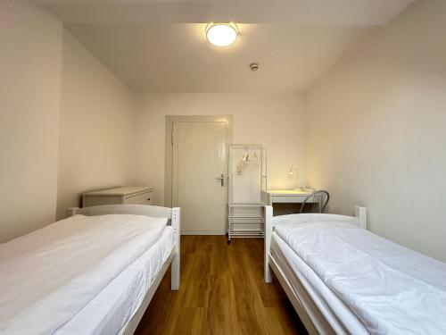 卡塞尔Cleo Apartments的小型客房的两张床,设有走廊