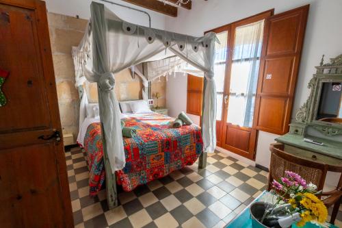 伊维萨镇Ibiza Boutique Guest House的一间卧室设有一张天蓬床和一张可调节的地板。