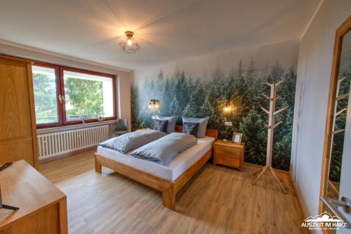 布劳恩拉格Auszeit im Harz Haus 3 Wohnung 6的卧室配有一张床,墙上挂有绘画作品