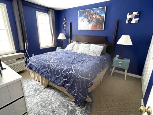 汉考克Mountain View Suite on Jiminy Peak Ski On Off -New的蓝色的卧室,配有一张蓝色墙壁的床