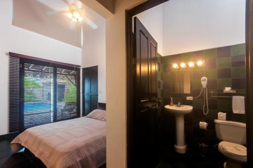 雅科Casa Gris in Jaco的一间带床、水槽和卫生间的浴室