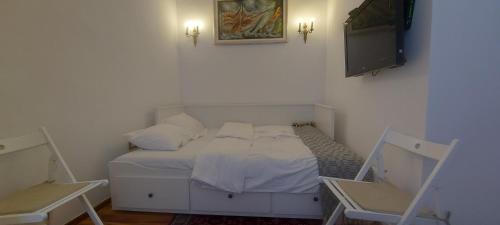 贝尔格莱德Tsar Dušan Apartment的卧室配有白色的床和电视