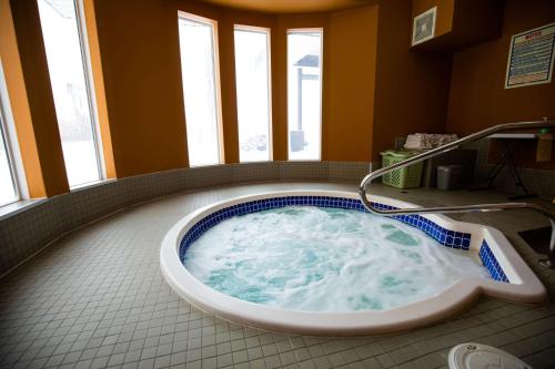 莱斯布里奇SureStay Plus Hotel by Best Western Lethbridge的带窗户的浴室内的按摩浴缸