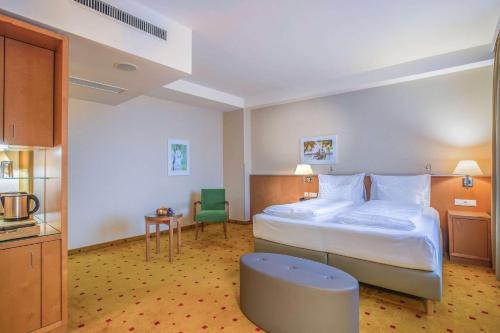 维也纳Quality Hotel Vienna的酒店客房带一张大床和一把椅子