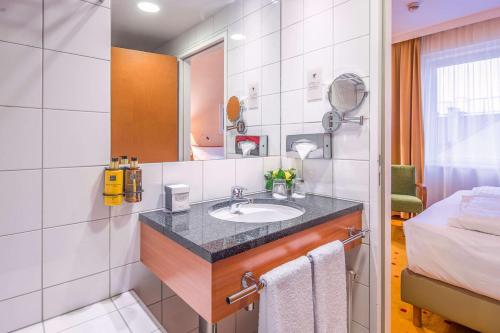 维也纳Quality Hotel Vienna的一间带水槽和床的浴室