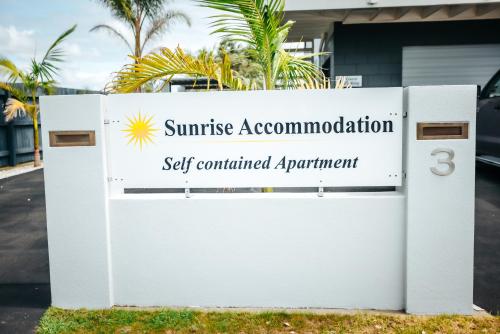 卡塔尼Sunrise Accommodation的一套日光服务住宿的标志,包括预约