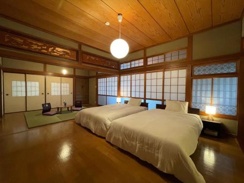 宫崎貸切宿KUMANO的一间带一张大床的卧室,位于带窗户的房间内