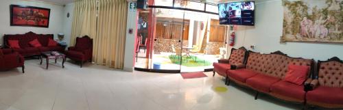 瓦拉斯Krusty Hostel II的一间设有红色沙发和电视的等候室