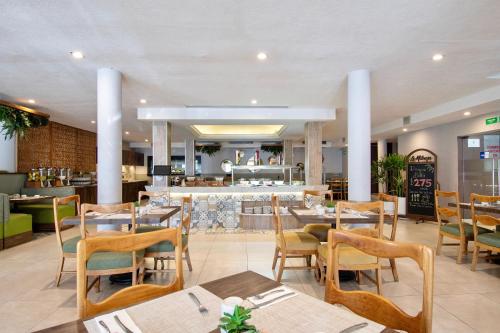 瓜达拉哈拉戴安娜广场酒店的一间带桌椅的餐厅和一间酒吧