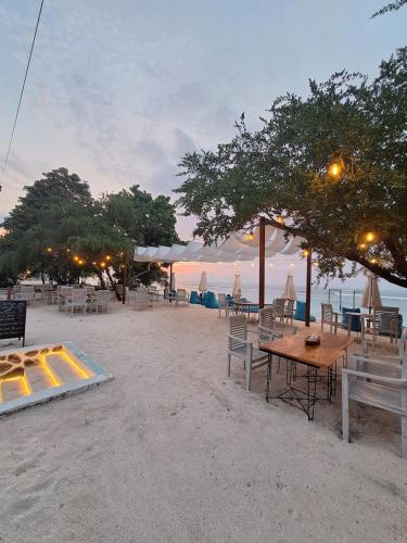 吉利特拉旺安Taj Maza Sunset Villas的海滩上的桌椅
