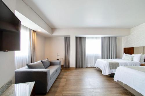 瓜达拉哈拉戴安娜广场酒店的酒店客房,设有两张床和一张沙发