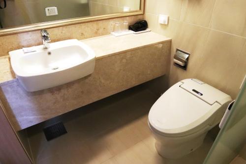 西归浦市Jeju Hotel the M的浴室配有白色卫生间和盥洗盆。