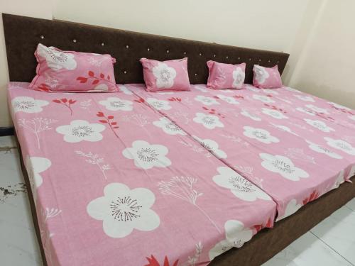 乌贾因Hanumant kripa geust house only for family的粉红色的床,上面有粉红色和白色的花