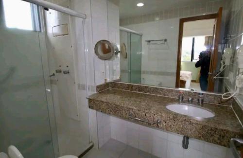 马瑙斯Tropical Executive Hotel APT 606的一间带水槽、淋浴和镜子的浴室