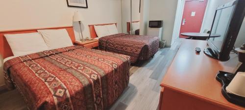 麦克默里堡艾斯客栈的酒店客房设有两张床和电视。