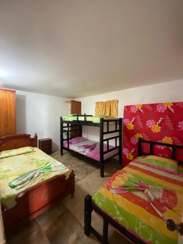 圣玛尔塔HERMOSA CASA CAMPESTRE EN SANTA MARTA的客房设有两张床和一张双层床。