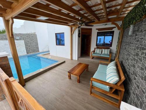 萨利纳斯Casa con piscina Punta Carnero的庭院设有游泳池和桌椅