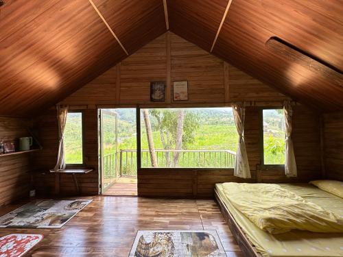 大叻Nhà Bên Suối - Homestay & Camping的客房设有床和大窗户。