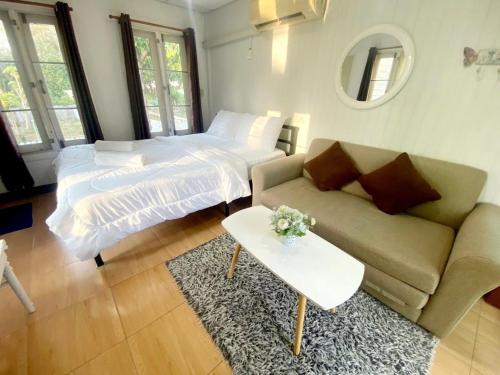 北冲Sleep Home Khaoyai的客厅配有沙发和1张床