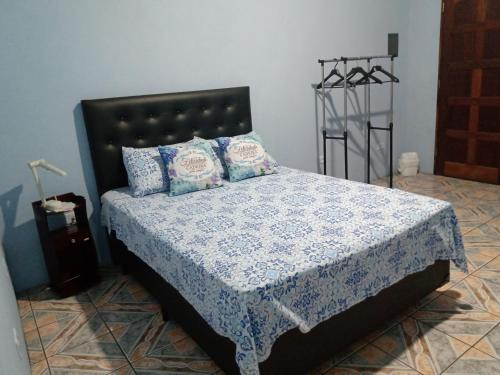 瓜鲁柳斯Quarto familiar, aeroporto Guarulhos的一间卧室配有一张带蓝色和白色床单及枕头的床。