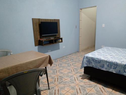 瓜鲁柳斯Quarto familiar, aeroporto Guarulhos的一间卧室配有一张床,墙上配有电视