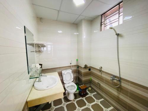Bản PiênKim Thoa Hotel Trung Khanh的浴室配有卫生间、盥洗盆和淋浴。